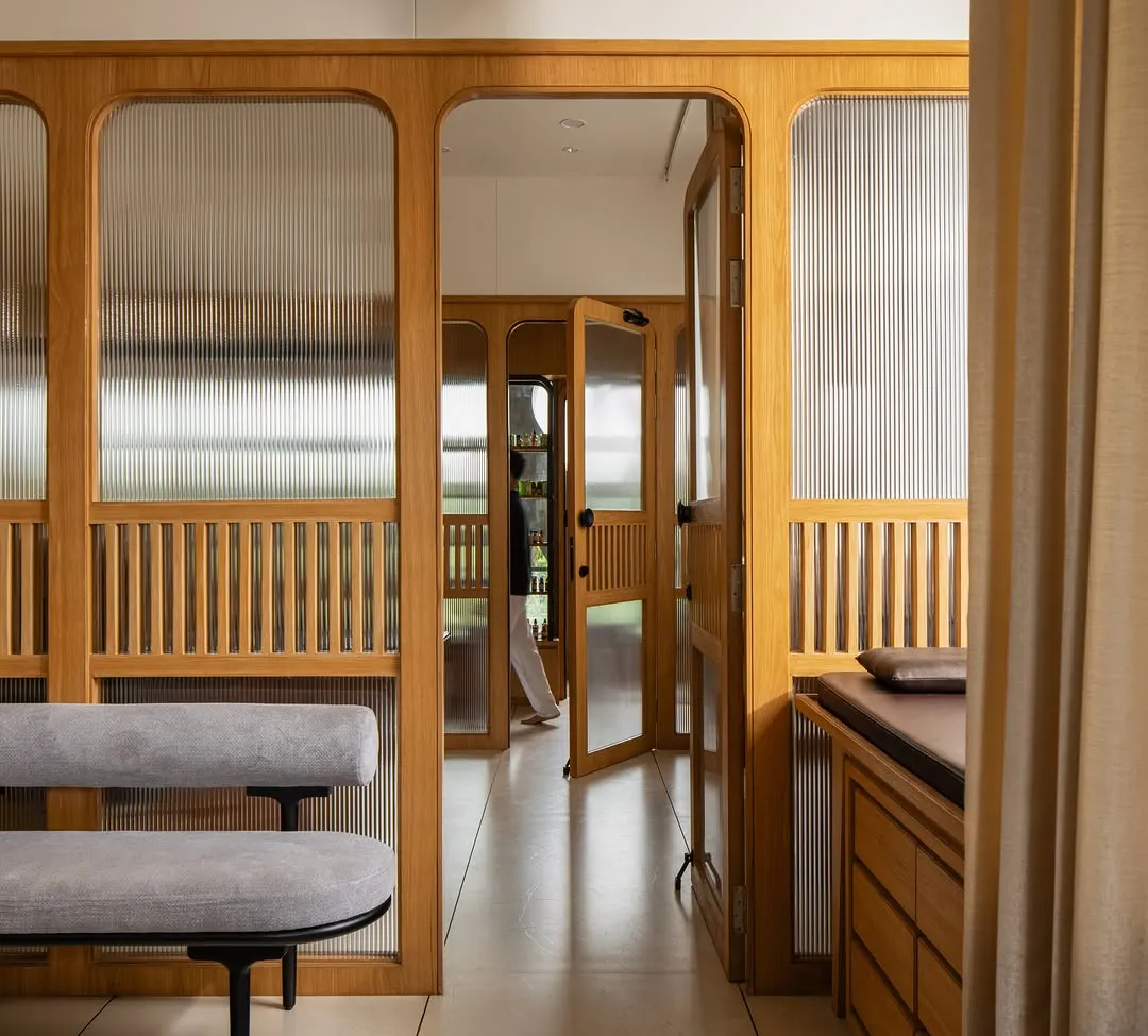 Timber-framed fluted glass partitions with arched openings