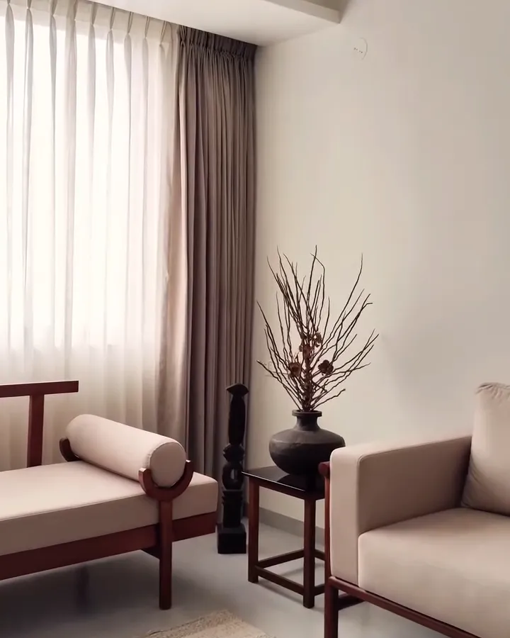 The Dvaya living room from the entrance, sheer curtains across the full window