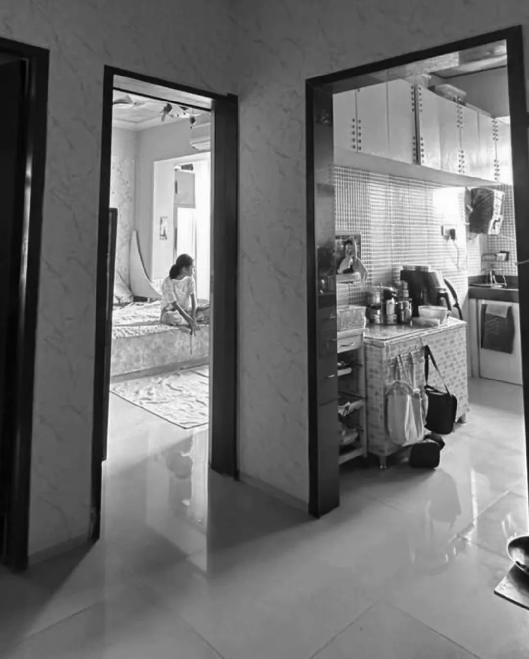 The flat before the work: a narrow passage, a bedroom and a cluttered kitchen opening off it